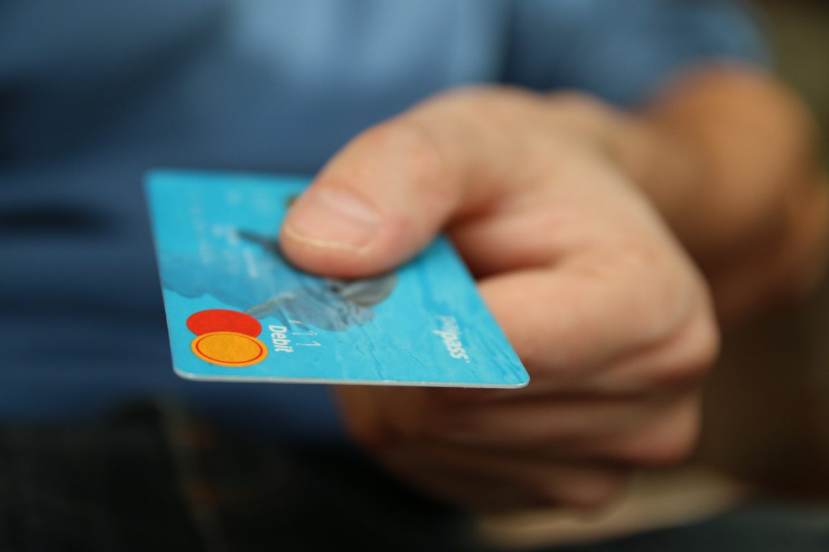 hand presenting a blue credit card