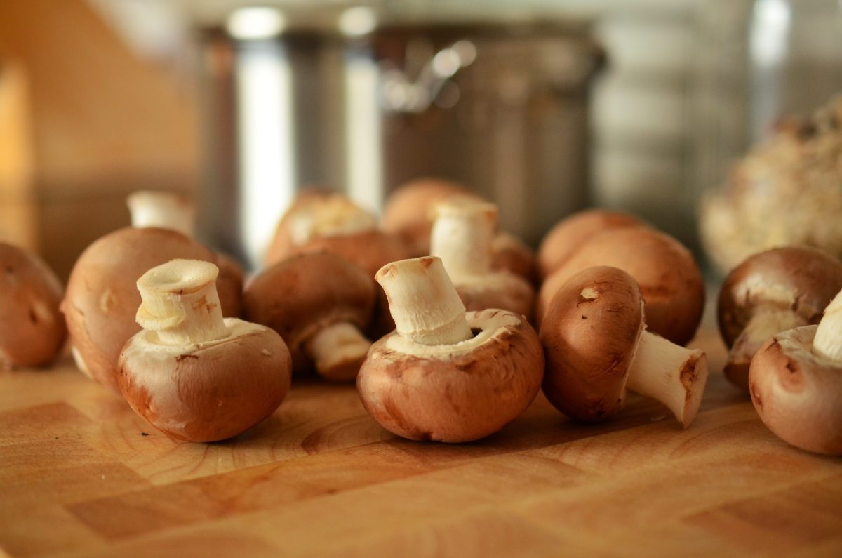 Close up of cut mushrooms on a wooden chopping board