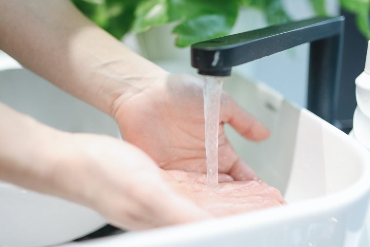 Close up image of hands being washed in a sink