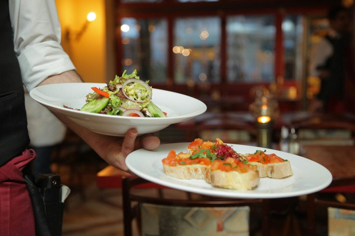 Restaurant staff holding plates of food